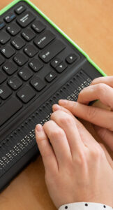 Person typing using a braille keyboard.